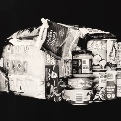 A black and white photograph of stacked basic grocery items, as art.