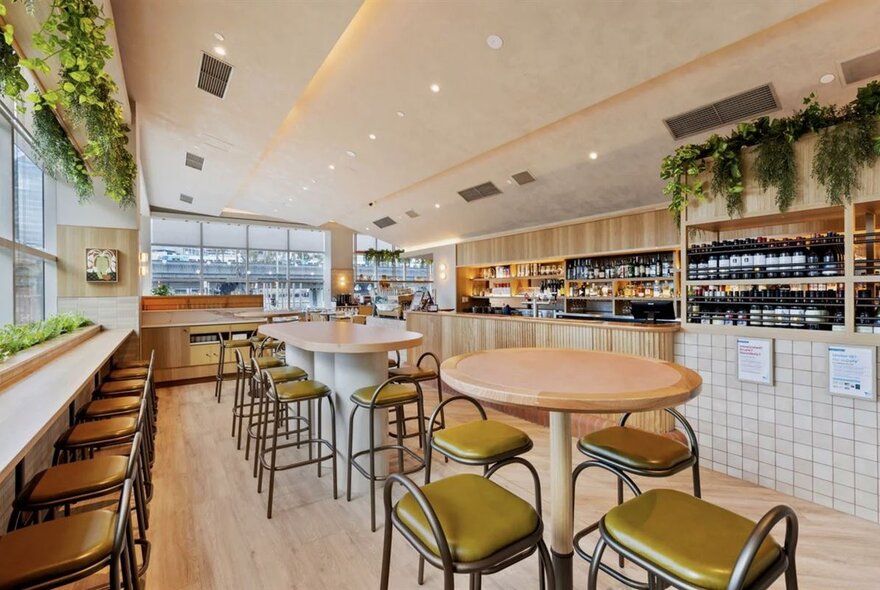Interior view of  brightly lit cafe with seating areas and a bar.