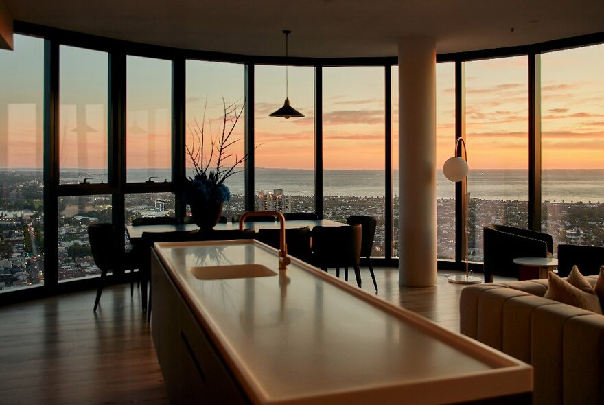 A hotel room with a city view at sunset