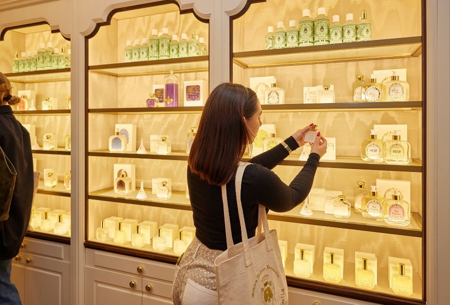 A woman browsing perfumes in a luxury beauty boutique.