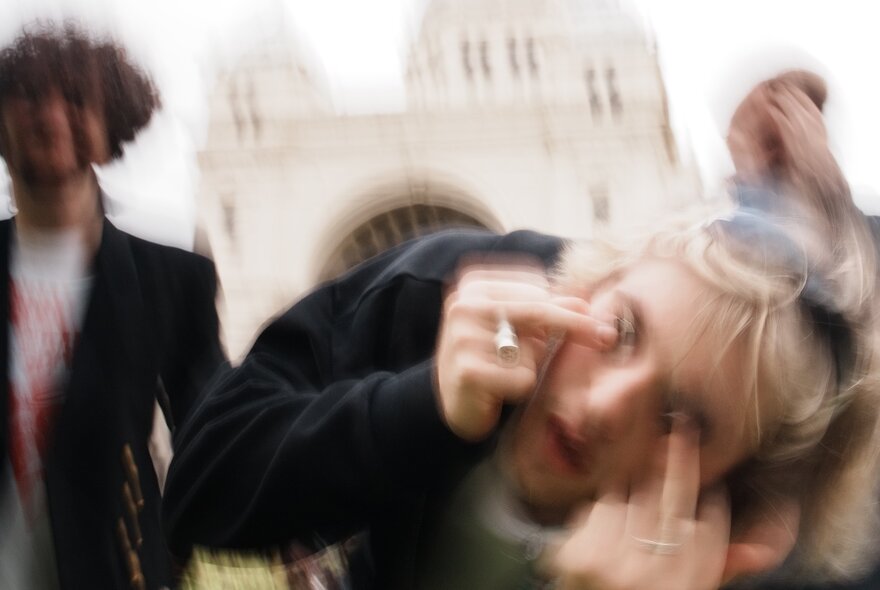 A blurry shot of three members of the band Seven Pound Halo, looking down toward the camera against a bright, overexposed white background.