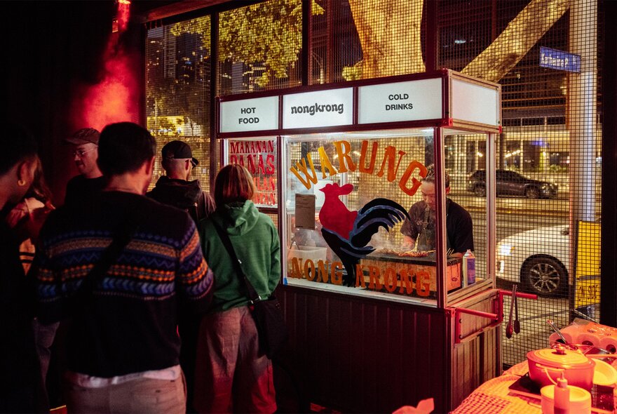 An Indonesian Warung food cart, with people waiting to be served.