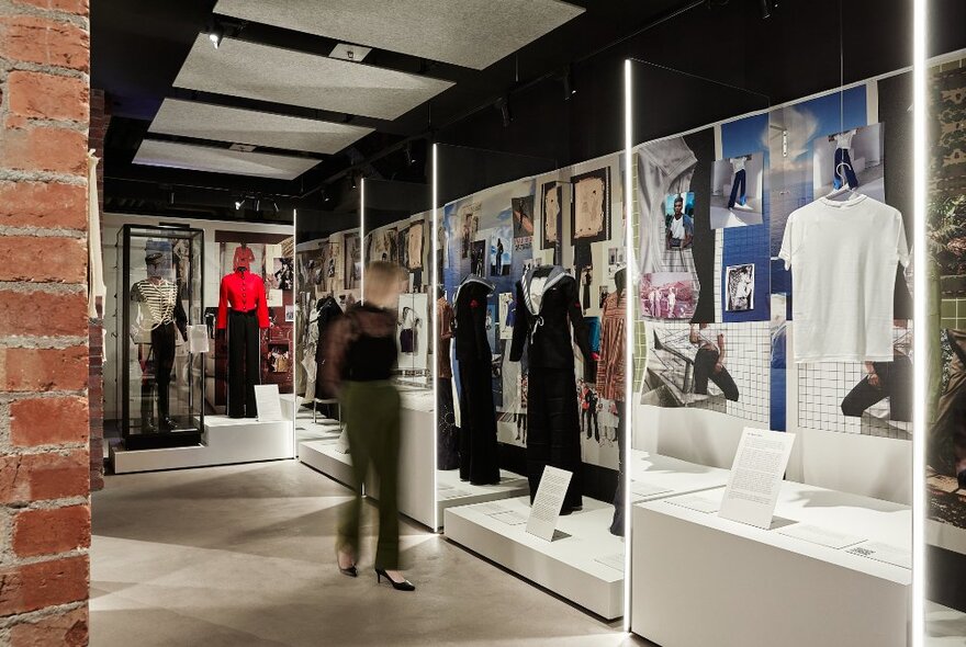 A person walking through an exhibition showcasing military clothing.