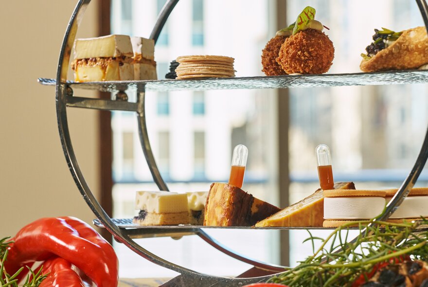 Cheese-themed savoury snacks presented in a decorative circular display near a window.