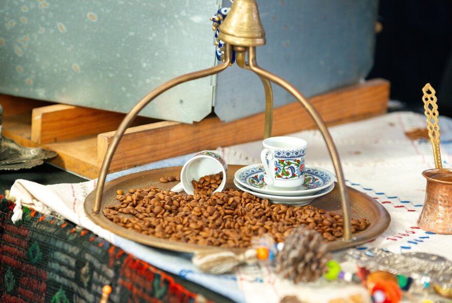 A table set with traditional Turkish coffee implements and beans.
