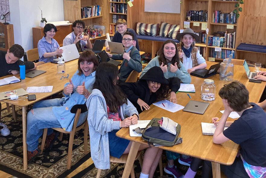 Children seated at tables with laptops.