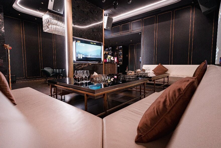 A warm toned bar area with tables and rust coloured cushions.