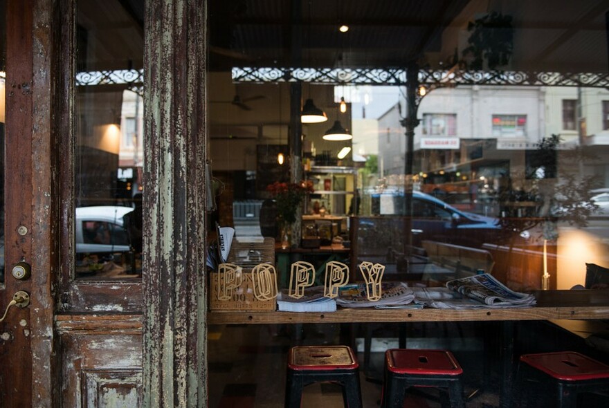 Cafe exterior with name on front window and Errol St reflection on glass.