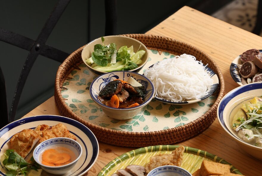Small dishes of Vietnamese food on round trays.