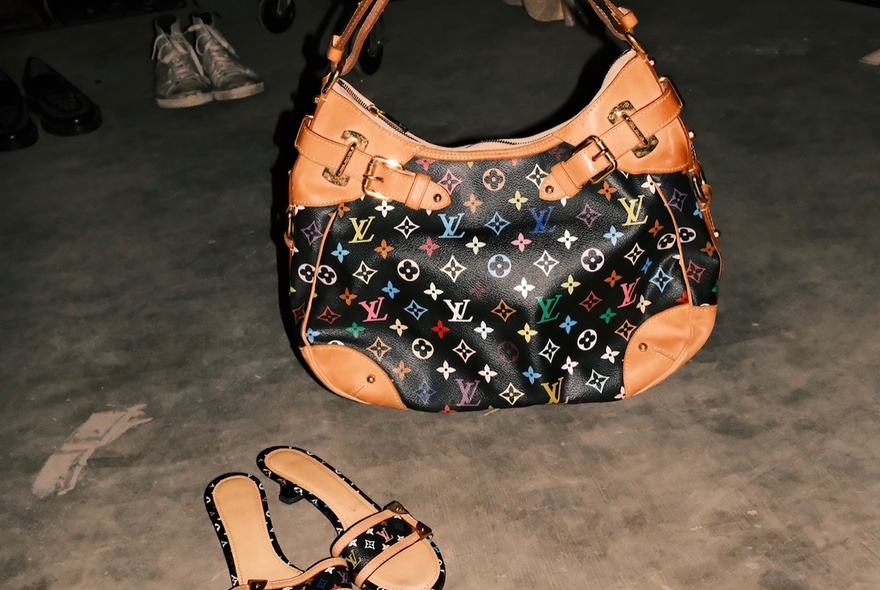 A vintage Louis Vuitton designer handbag and matching slip on sandals.
