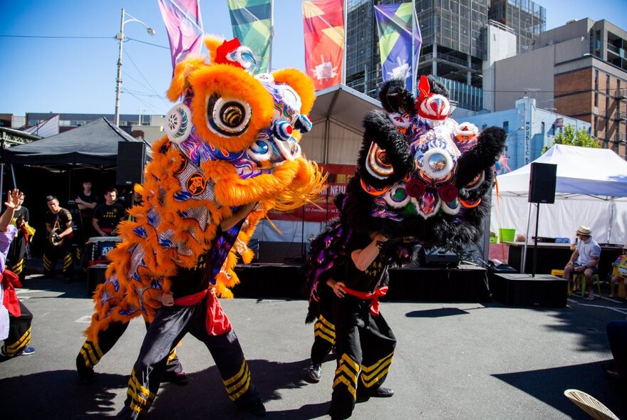 Lion dance performers outside stalls at Queen Vic Market.