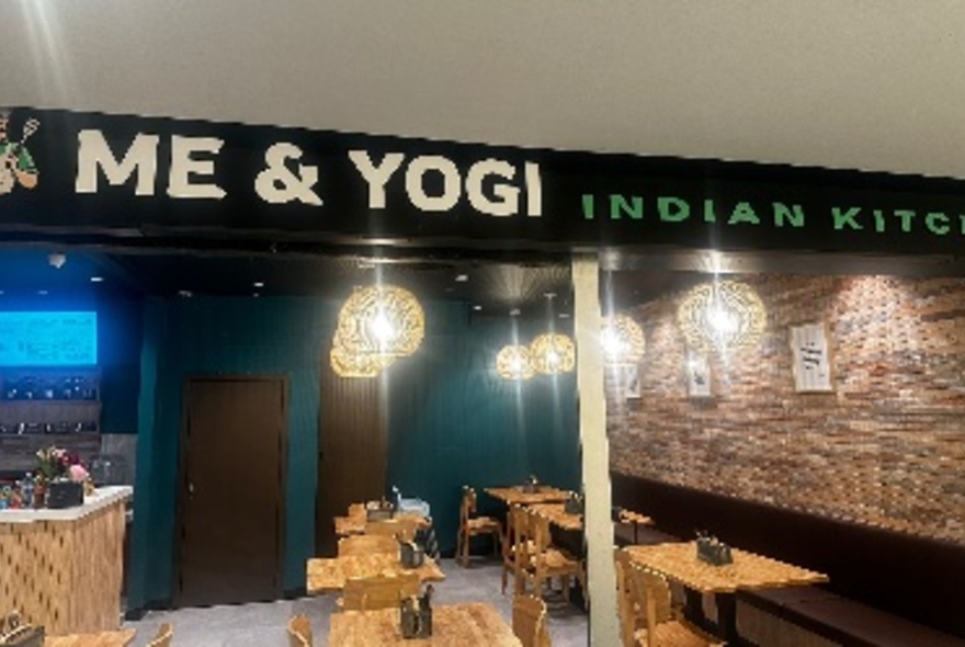 View into the small open interior of a cafe style restaurant on the ground floor of a building.