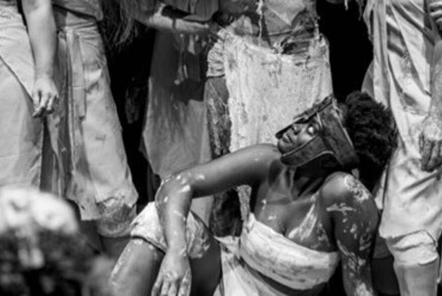Performers with painted bodies and stylised white clothing; black and white image.
