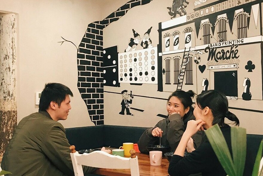 People drinking from mugs at a cafe.