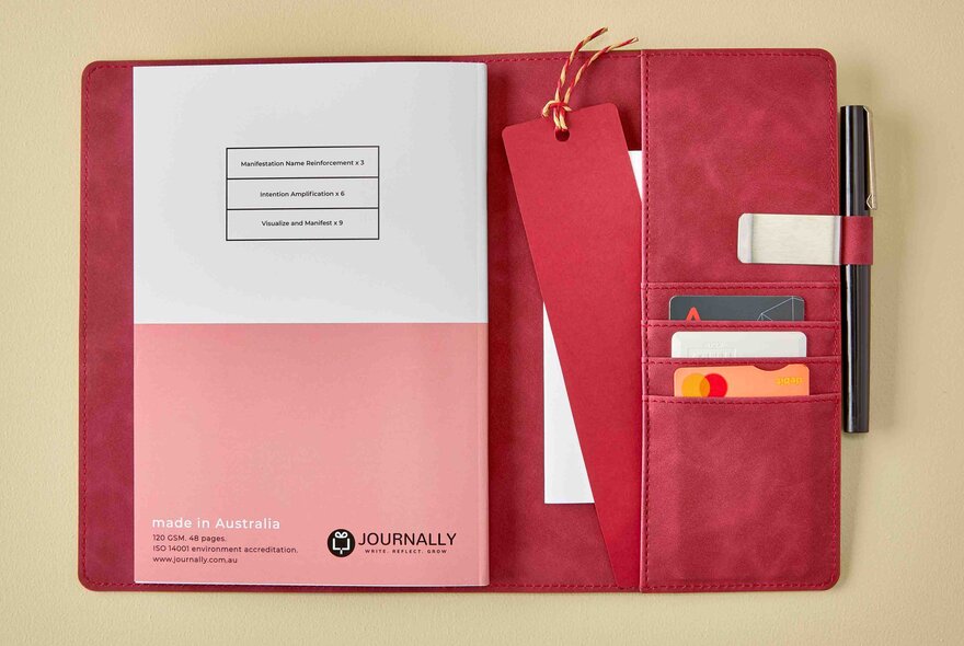 A journal in a folder with pockets, pen and strap.
