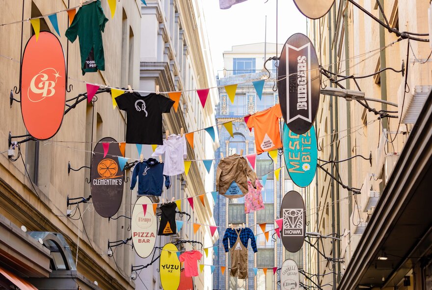 Rows of clothing and uniforms suspended over Degraves Street in central Melbourne.