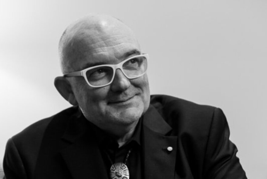 A black and white image of James Morrison looking bemused wearing white glasses. 