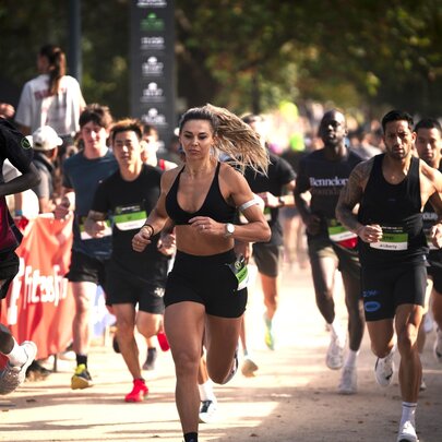 Runners wearing black competing in a run around the Tan track in Melbourne.