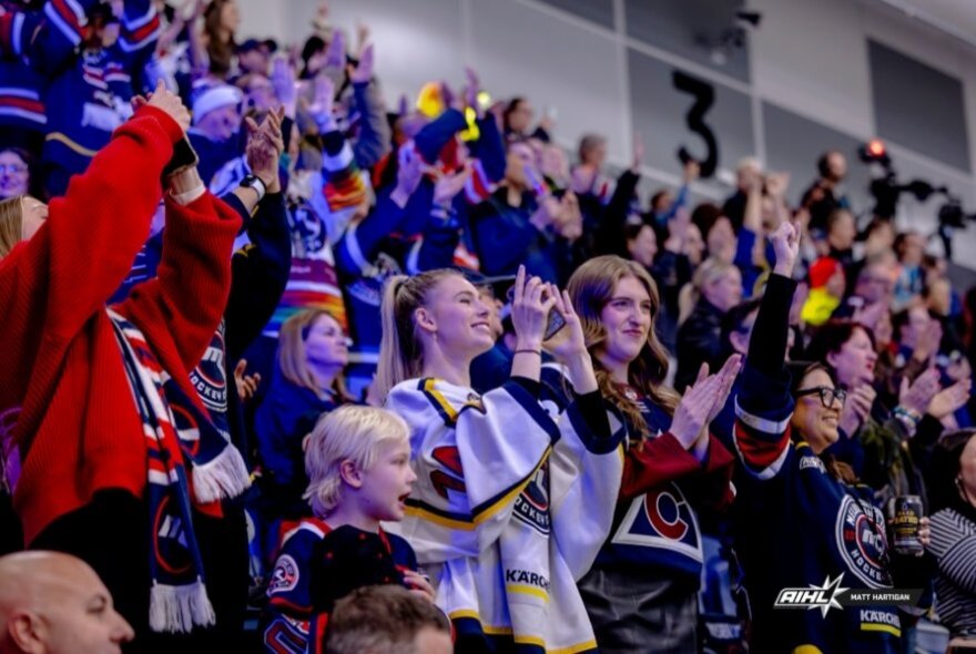 Ice hockey fans in a crowded stadium.