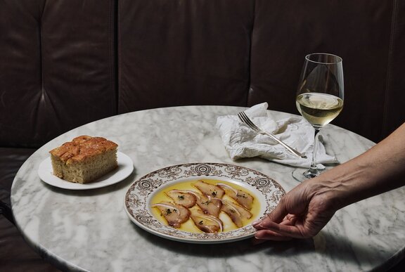 A table with ceviche, focaccia and wine.