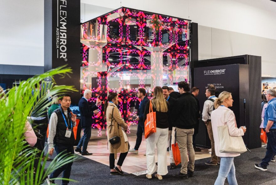 People walking around a design show inside a large expo hall.