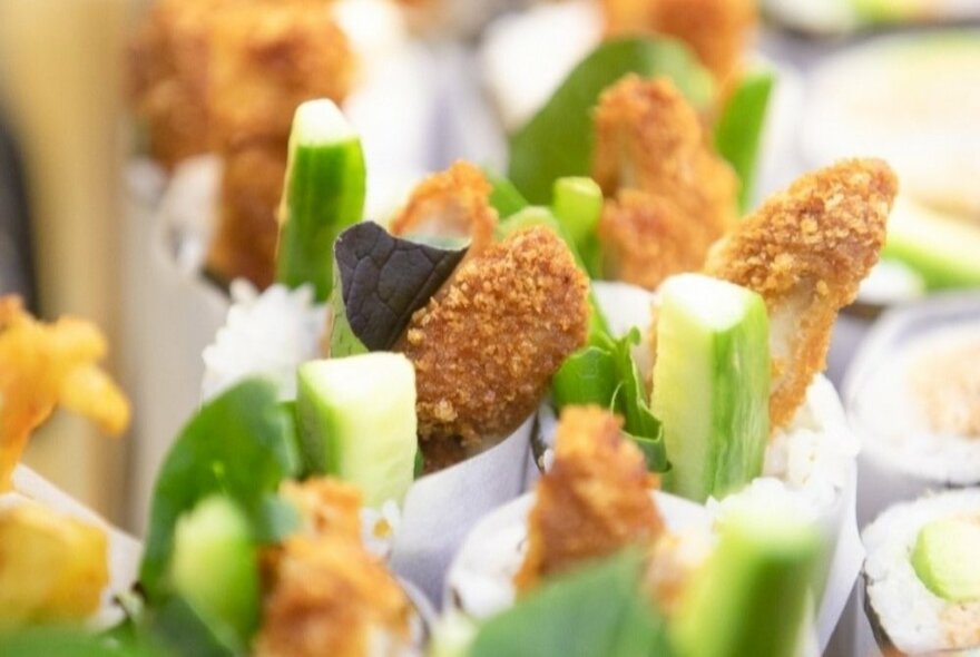 A close-up of rice rolls with vegetables and fried ingredients.