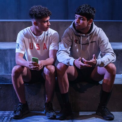 Two young people seated on stone steps.