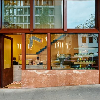 The external glass facade of BakeStand with rust-coloured columns.