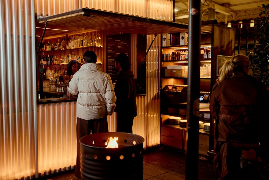 Two people ordering something at a pop up window.