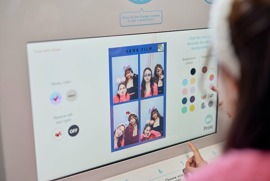 Someone using the touchscreen to customise photo booth pictures.