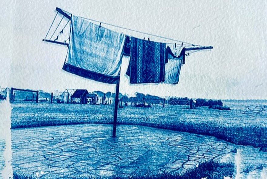 Blue tinged cyanotype print of a hill hoist washing line in a barren field with garments and fabric pegged to it.