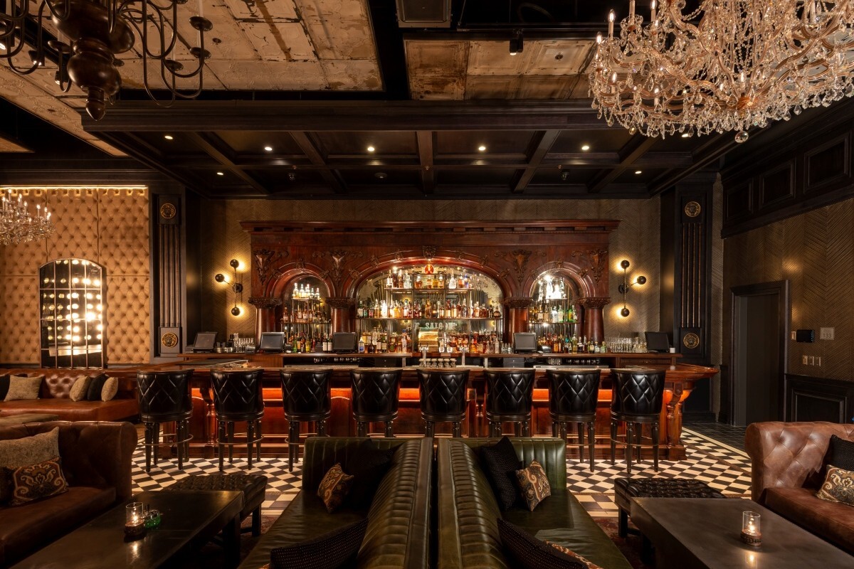 A stylish cocktail bar with couches and chandeliers.