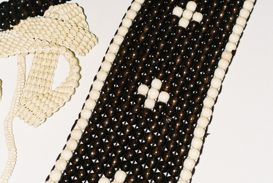 Examples of beaded art showing a black and white pattern. 