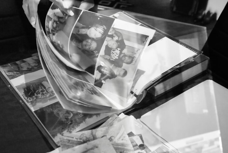 Folders with pages of black and white photographs being turned.