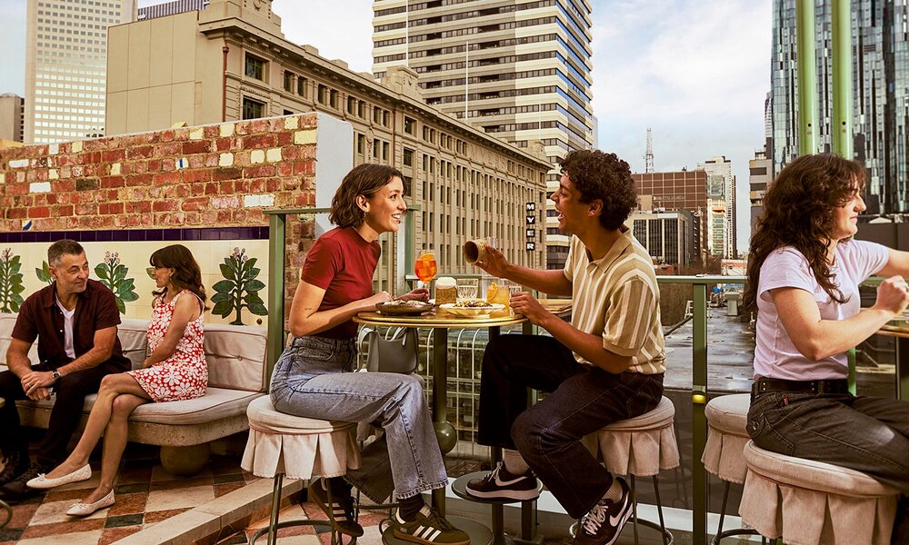 People dining on a rooftop in the city.