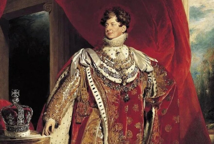 Royal portrait of King George IV wearing a heavily embellished scarlet cloak and animal pelt neckdress, his crown resting on the table beside him.