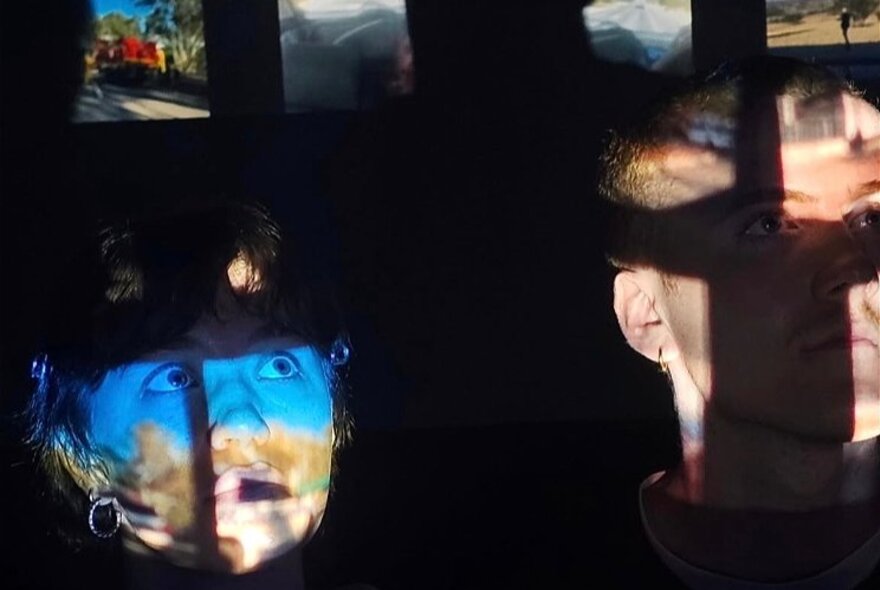 Dappled shadows playing on the faces of a man and a woman.