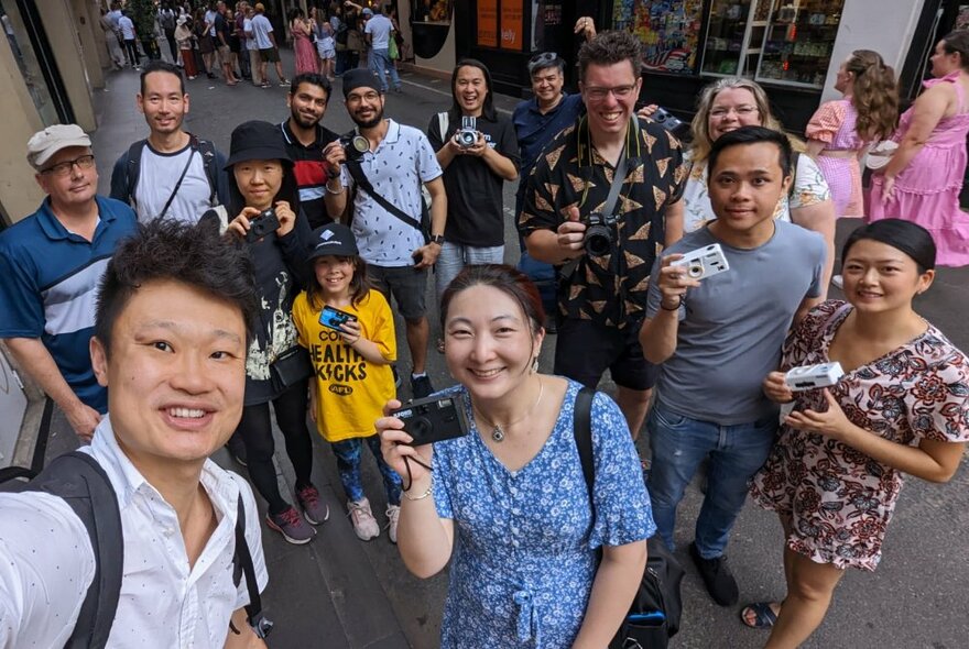 A selfie shot of a group of people with their cameras in a Melbourne laneway.