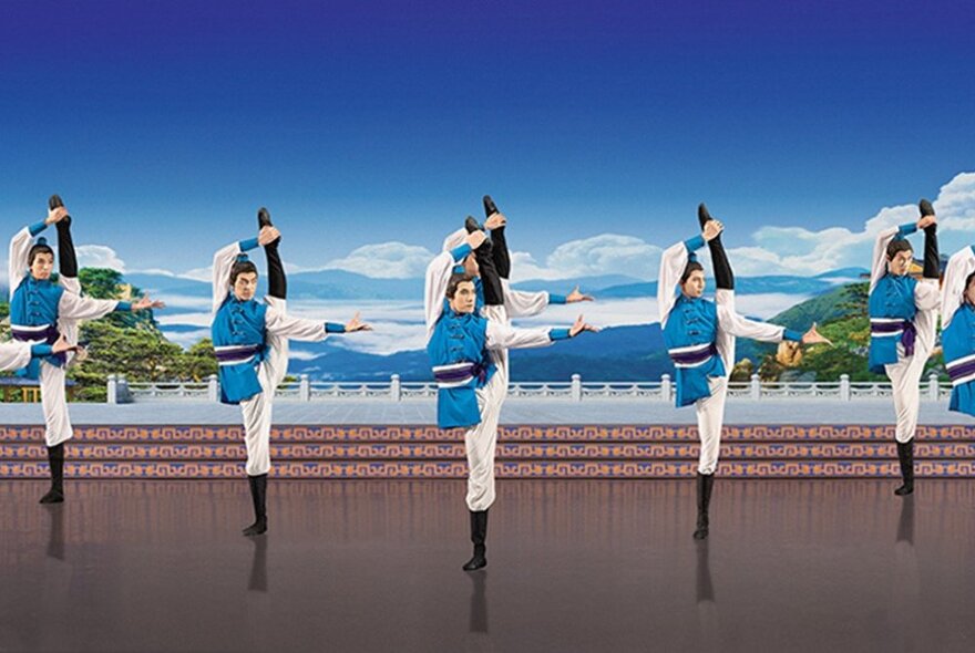 Five Chinese dancers all standing on one leg with the other leg raised high over their head. 