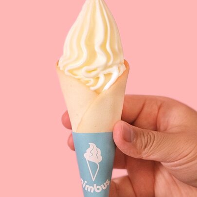A hand holding a soft serve ice cream.