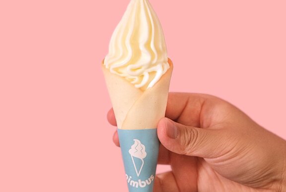 A hand holding a soft serve ice cream.