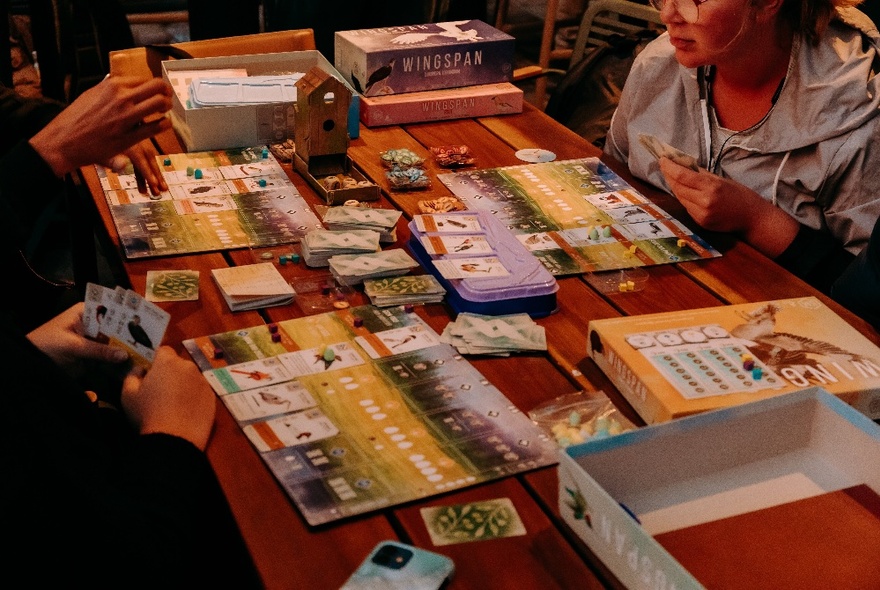 People at a table playing board games. 