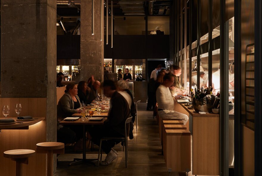 Interior of Antara restaurant, with diners seated at tables, and other seated at high stools at the bar area.