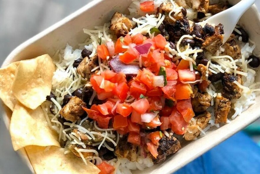 A takeaway container with Mexican food, tortilla chips and salsa.