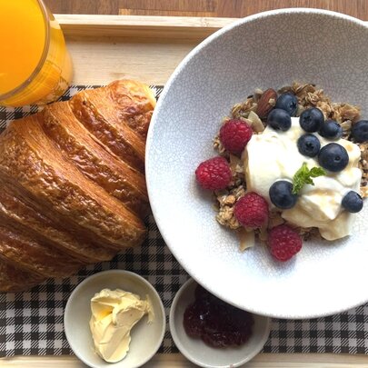 Breakfast tray with orange juice, croissant and muesli.