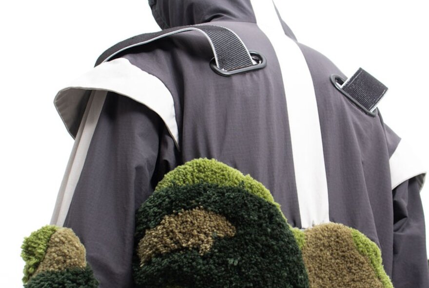 A black jacket, with close up details of green furry trim.