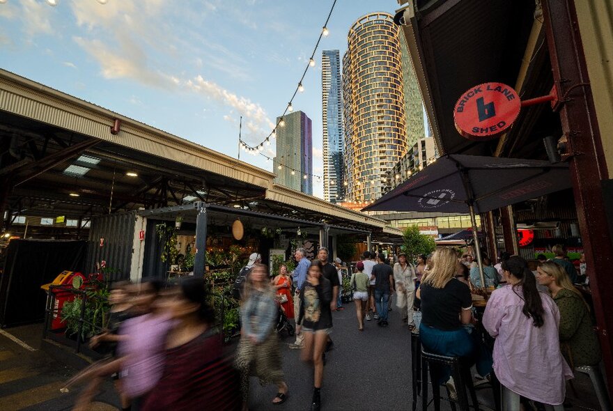 People walking around the Queen Victoria Market at twilight.