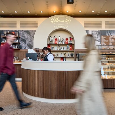 People in blurred motion past a Brunetti Classico pop-up shop