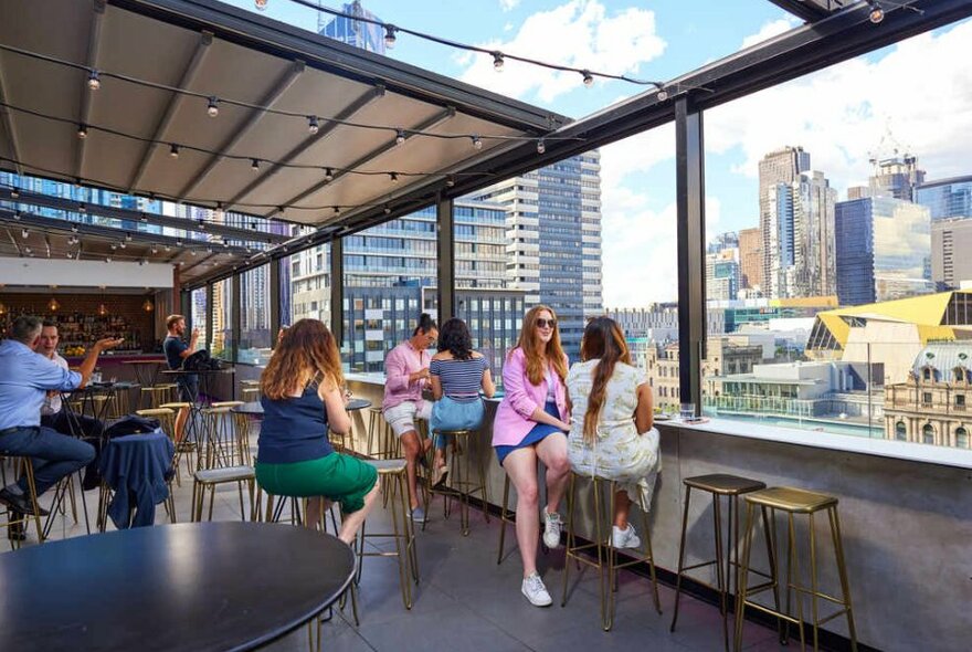 People sitting at a rooftop bar on a sunny day