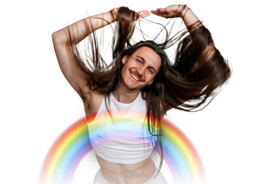 A man with very long hair draped over his arms above his head, a short cropped singlet and a rainbow over his torso. 